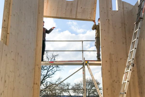 Arbeiten als Zimmerer oder Schreiner auf der Baustelle eines Holzhauses
